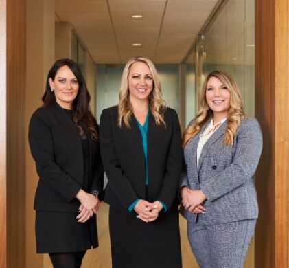 Jennifer L. Ashley, Tara R. Devine and Jaclyn J. Kurth standing in the Chicago office hallway of Salvi, Schostok & Pritchard